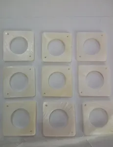 Detail view of nine square cream pearlescent shell pieces for DIY jewelry components