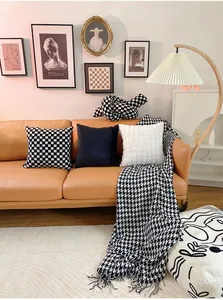 Detailed view of luxury black and white checkered and rabbit fur textured pillows on sofa