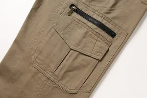 Detailed macro shot of khaki cotton cargo pants featuring zipper and flap pockets