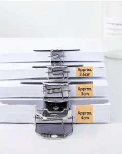 Detail view showing clamping thickness of stainless steel bull clips on paper stacks