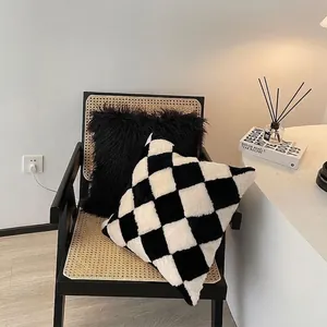 Soft black and white checkerboard plush pillow on a black wooden chair for home decor
