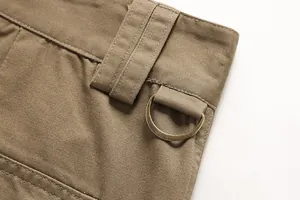 Close-up detail of men's cotton cargo pants showing a bronze D-ring and sturdy belt loop