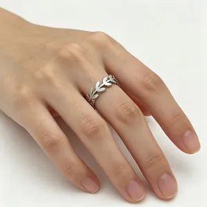 Detail view of a vintage silver stainless steel ring with an olive leaf branch pattern.
