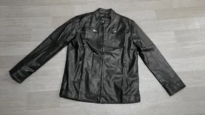 Dettaglio di una giacca in ecopelle nera slim fit con colletto alla coreana e zip