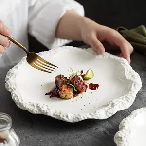 Elegante piatto piano in ceramica bianca con bordo a trama rocciosa per la tavola