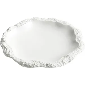 Elegante piatto piano in ceramica bianca con un design unico del bordo a trama rocciosa