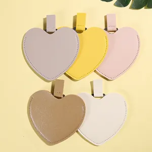 Detailed macro view of heart-shaped leather mirror storage cases in five pastel colors