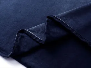 Dettaglio macro del tessuto e dell'orlo della maglietta vintage in cotone blu da 305g