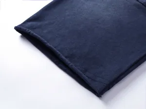 Dettaglio ravvicinato dell'orlo arrotolato con doppia cucitura su t-shirt in cotone.