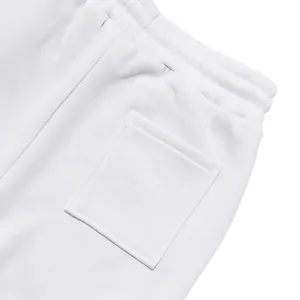 Vista dettagliata dei pantaloni joggers bianchi in pile con tasca e vita elastica