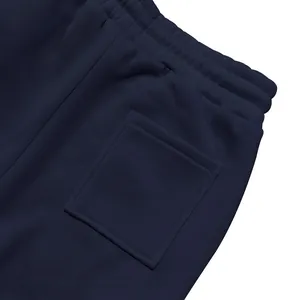 Vista macro dettagliata della tasca posteriore sui pantaloni della tuta in pile blu navy.
