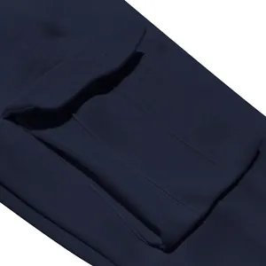 Dettaglio ravvicinato di una tasca cargo con patta su pantaloni pesanti in pile blu.