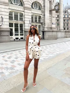 Fashionable polka dot two-piece set with tie-waist top and shorts in city background