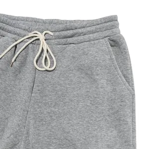 Dettaglio ravvicinato di pantaloni sportivi grigi in pile pesanti con coulisse in vita.