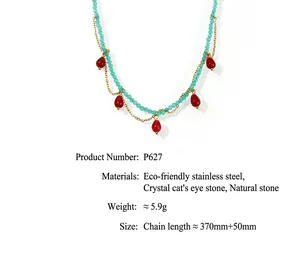 Close-up of handmade beaded necklace with turquoise beads and red teardrop stone pendants