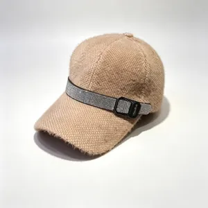 Détail d'une casquette d'hiver beige duveteuse avec une bande de strass luxueuse