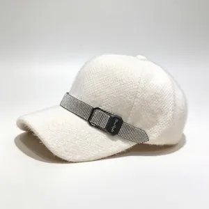 Détail d'une casquette de baseball d'hiver blanche en peluche avec ceinture en strass