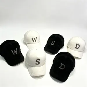 Plush winter baseball caps with rhinestone letters in black and white colors.