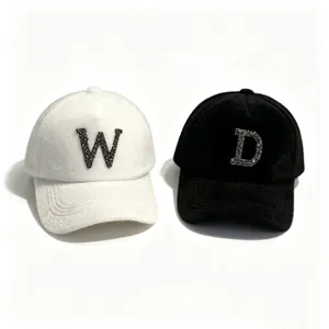 Close-up of white and black mink fur baseball caps with sparkling rhinestone letters W and D