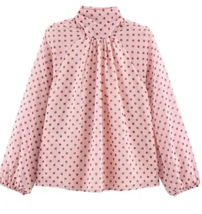 Gedetailleerd achteraanzicht van een roze chiffon blouse met bruine stippen en plooien