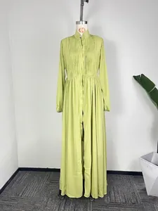 Détail d'une élégante robe longue plissée vert citron à manches longues boutonnée