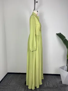 Vue latérale d'une robe longue plissée vert citron à manches longues sur un mannequin de mode