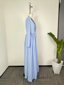 Vue de côté d'une robe longue bleu clair à manches longues et corsage plissé
