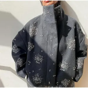 Close-up of elegant grey wool jacket featuring sparkling snowflake rhinestone patterns