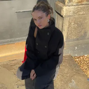 Woman wearing a black oversized wool jacket with buttons in outdoor street style.