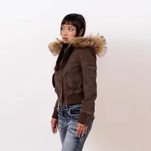 Close-up detail shot of a stylish brown bomber jacket with a voluminous faux fur hood
