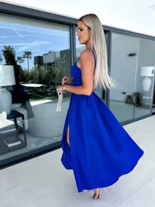 Elegantes königsblaues Maxikleid mit hohem Schlitz von der Seite in moderner Umgebung.