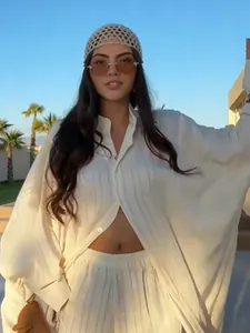Full view of a relaxed white striped long shirt and wide-leg pants set for women