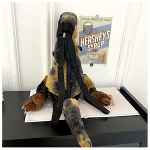 Dettaglio dello zaino a dinosauro in peluche con cinghie e chiusura a zip posteriore