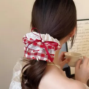 Zoete rode ruitjes scrunchie met hartjes, kant en een strik gedragen door een model