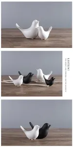 Figuras de pájaros de cerámica minimalistas en blanco y negro sobre superficie madera