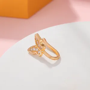 Macro view of a gold-plated butterfly nose cuff with micro-pave crystals and U-shaped clip.