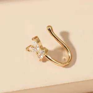 Close-up of gold U-shaped faux nose ring with sparkling rhinestone butterfly design