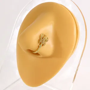 Detailed macro shot of a golden scorpion-shaped non-piercing copper nose clip