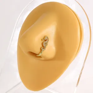 Close-up detail of a gold seahorse nose clip with clear cubic zirconia on display model