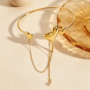 Macro view of gold lava heart bangle with elegant dangling tassel chains and crystal