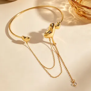 Detailed close-up of a golden lava heart arm cuff featuring elegant long chain tassels