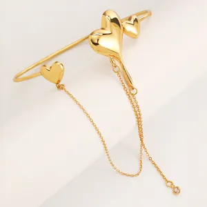 Detailed macro view of golden lava heart bracelet with elegant long tassel chain.