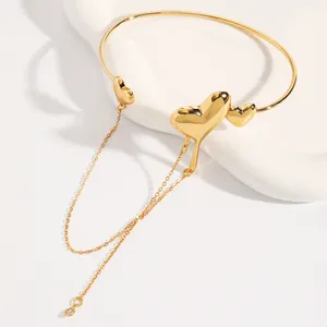 Close-up view of gold lava heart bracelet with elegant dangling chain tassel detail.