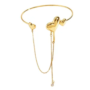Detail view of gold lava heart arm ring with long hanging tassel chain