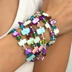 Detailed view of colorful multi-layered beaded necklace with iridescent shell pieces.