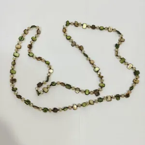 Detail view of retro Maillard style beaded necklace with green and brown shell-like beads.