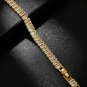 Detailed close-up of a gold tennis bracelet featuring elegant baguette-cut crystals