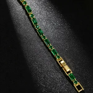 Close-up of elegant gold-plated bracelet with emerald green stones and secure clasp