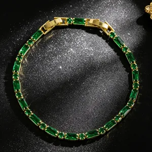Detailed macro shot of an elegant emerald green gemstone tennis bracelet with gold plating