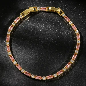 Close-up macro view of gold tennis bracelet with pink baguette and clear crystals